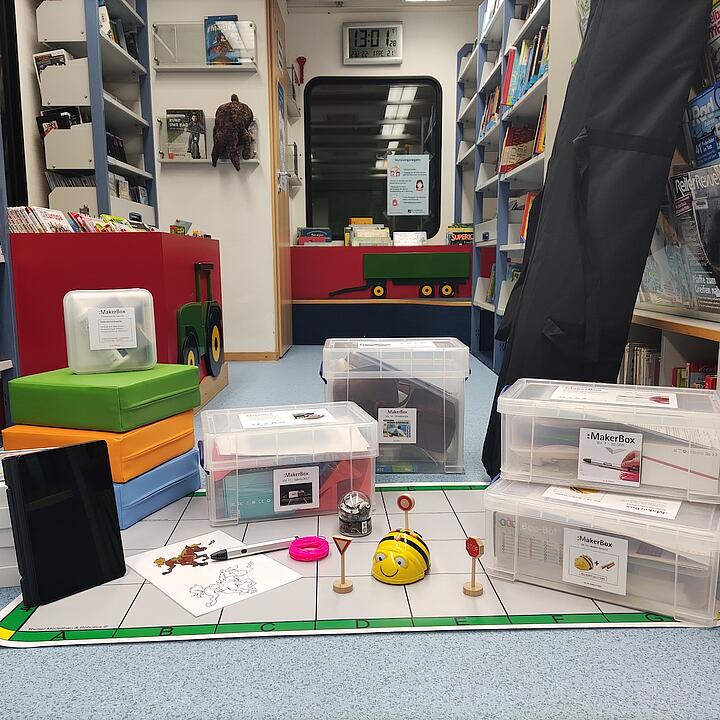 Makerboxen und andere Materialien aufgereiht auf dem Boden der Bibliothek