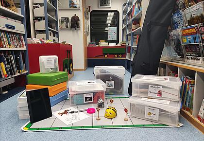 Makerboxen und andere Materialien aufgereiht auf dem Boden der Bibliothek