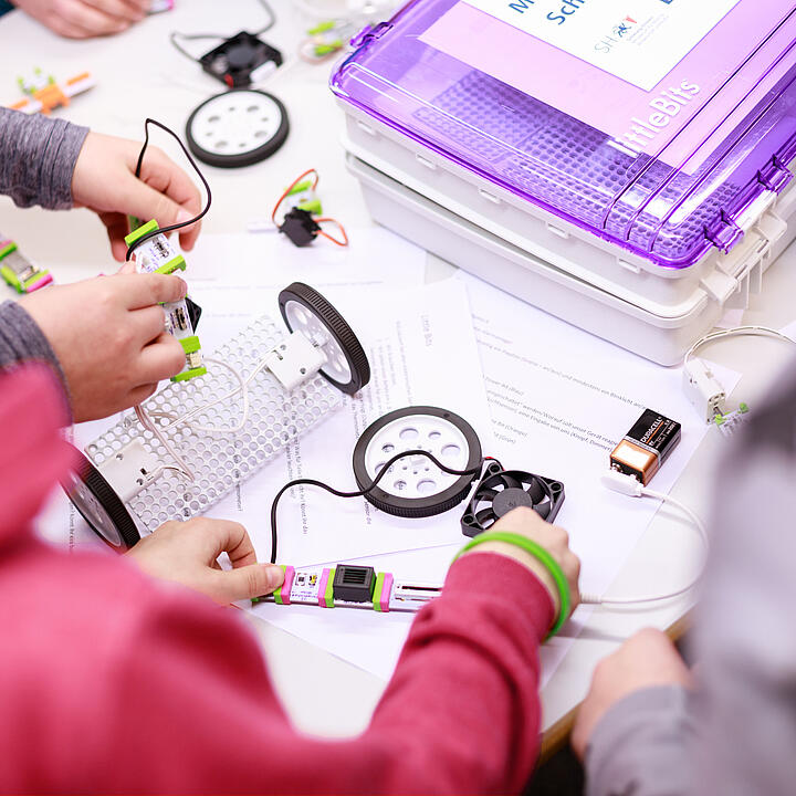 Über die Schultern von zwei Kindern sind Bestandteile eines mobilen Makerspaces zu sehen.